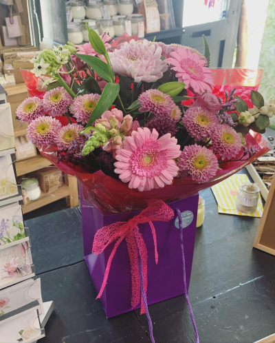 Blushing Meadow - A stunning collection of pink and green seasonal flowers in toning packaging. This bouquet is designed to impress and uplift any space.